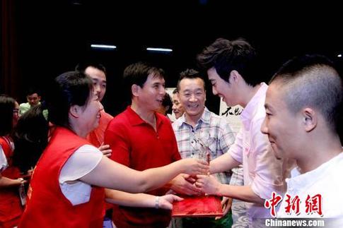 志愿者为爱心演员颁发奖杯和证书。　张道正 摄