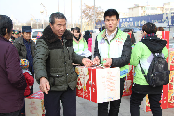 义工帮受助家庭搬运慰问物资。