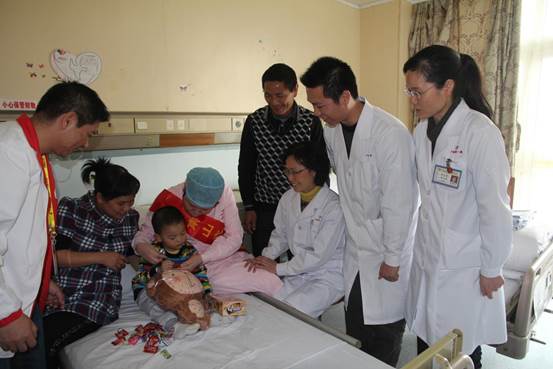 说明: 莫明聪（右2）带队开展参加“阳光乐园：关爱先心患儿”项目