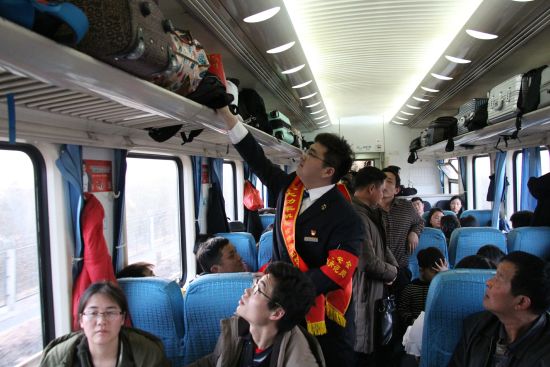 王冠雄正在巡视整理车厢行李架